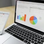 Ordinateur portable affichant des tableaux et des graphiques avec calendrier de tablette pour l'analyse et la planification des données.