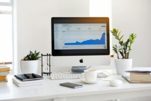 Un espace de travail propre et contemporain comprenant un bureau avec des analyses à l'écran et des plantes pour un look frais.