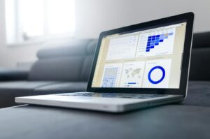 Ordinateur portable élégant présentant des analyses de données et des graphiques sur l'écran dans une pièce lumineuse.